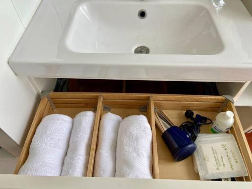 - un tiroir dans une salle de bains pourvue d'un lavabo et de serviettes dans l'établissement Logis Confortable - accueillant, à Marseille