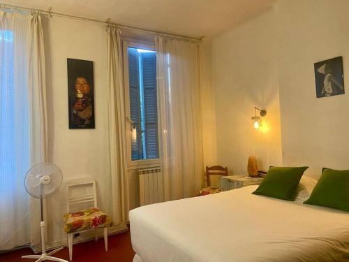 une chambre avec un lit blanc et une fenêtre dans l'établissement Logis Confortable - accueillant, à Marseille