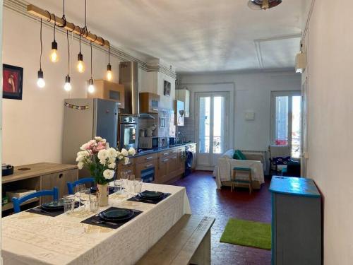 - une cuisine avec une table et des fleurs dans l'établissement Logis Confortable - accueillant, à Marseille