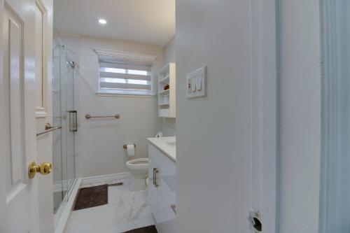 Un baño blanco con ducha y WC. en Beautiful House In Scarborough, en Toronto