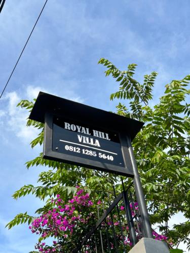 a sign for the royal hill villa with purple flowers at Royal Hill Villa Cisarua Puncak in Puncak