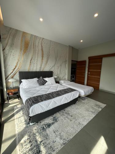 a bedroom with two beds and a rug at Royal Hill Villa Cisarua Puncak in Puncak