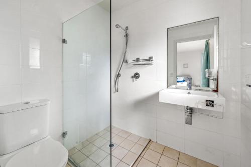a bathroom with a shower and a toilet and a sink at Paperbarks by the beach in Hawks Nest