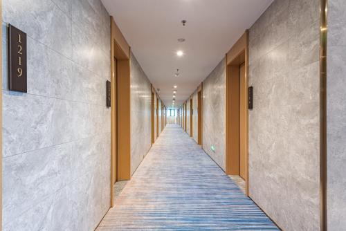 a corridor of a hallway with a long hallway at Poltton International Apartment - Guangzhou Knowledge City Wangcun Subway Station in Jiufo