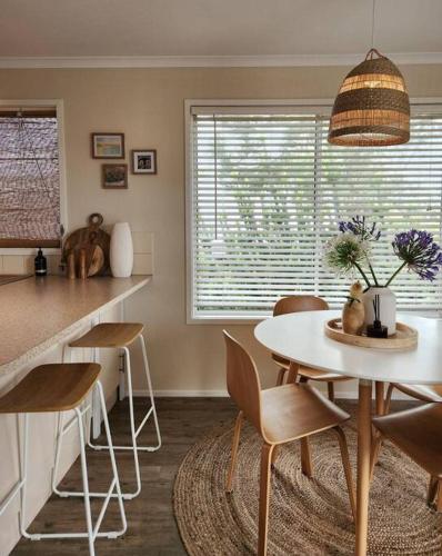 a kitchen with a table and chairs and a table and a counter at Banksia Retreat, A couple's sanctuary on Aldinga Beach in Aldinga Beach