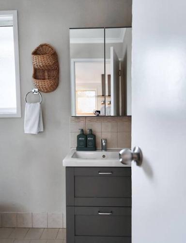 a bathroom with a sink and a mirror at Banksia Retreat, A couple's sanctuary on Aldinga Beach in Aldinga Beach