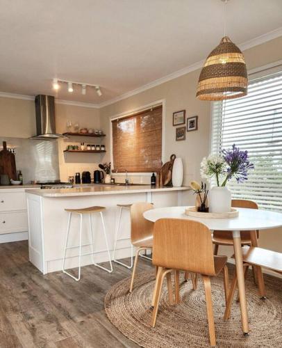 a kitchen with a table and chairs and a dining room at Banksia Retreat, A couple's sanctuary on Aldinga Beach in Aldinga Beach