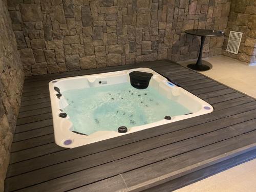 a jacuzzi tub with a black bucket in it at Maravilloso Depto nuevo 2D 2B centro frente al lago con piscina techada temperada y jacuzzi in Puerto Varas