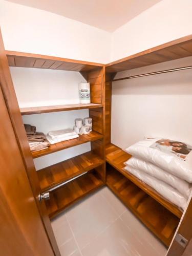 a walk in closet with wooden shelves and towels at Sendero del Botánico in Santiago de los Caballeros