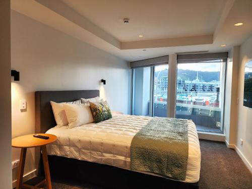 a bedroom with a bed and a large window at U Suites on Oriental Parade in Wellington