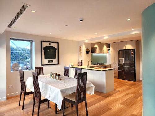 a kitchen and dining room with a table and chairs at U Suites on Oriental Parade in Wellington