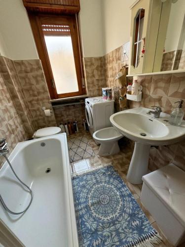 a bathroom with a tub and a sink and a toilet at Appartamento Primavera in Scalea