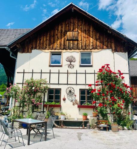 a house with flowers in front of it at Wengerwirt zur Laube Komfortzimmer Deluxe in Weng im Gesäuse