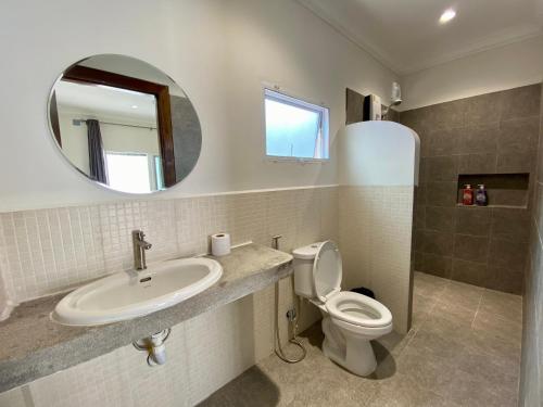 a bathroom with a sink and a toilet and a mirror at Muni Residence & Spa in Battambang