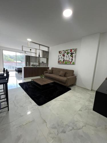 ein Wohnzimmer mit Sofa und Tisch in der Unterkunft Estudio moderno con ubicacion estrella! in Vila El Carmen