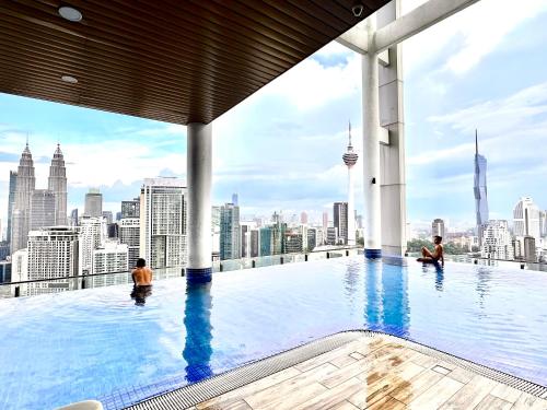 a infinity pool on the top of a building with a city skyline at The Luxe Colony KLCC By AZHA in Kuala Lumpur