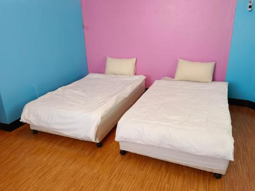 two beds sitting next to each other in a room at Royal Land Mae Klong Hotel in Samut Songkhram