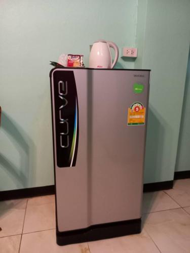a refrigerator with a tea kettle on top of it at Royal Land Mae Klong Hotel in Samut Songkhram