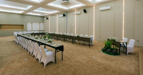 a large room with a long table with white chairs at Grand Istana Rama Hotel in Kuta