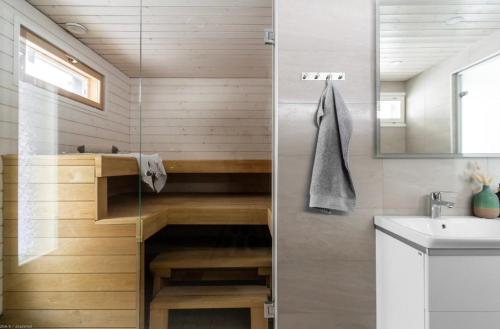 a bathroom with a shower with a sink and a mirror at Beautiful house in peaceful area in Vantaa