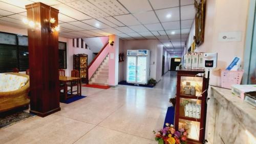 a store hallway with a table and a staircase at Royal Land Mae Klong Hotel in Samut Songkhram
