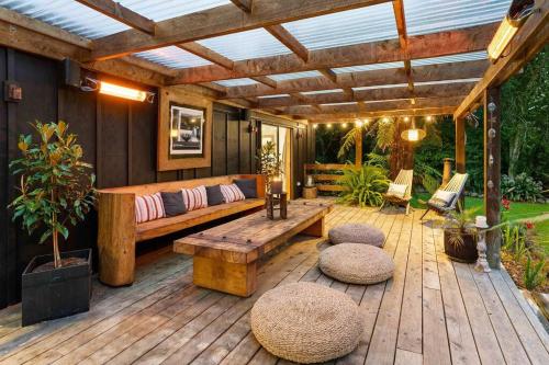 a wooden patio with a bench and a wooden pergola at Isness - Your Haven on Hautere in Te Horo