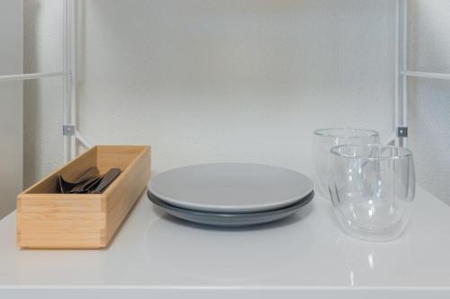 a table with a plate and two glasses and a wooden box at エルザビル411 in Sumiyoshi