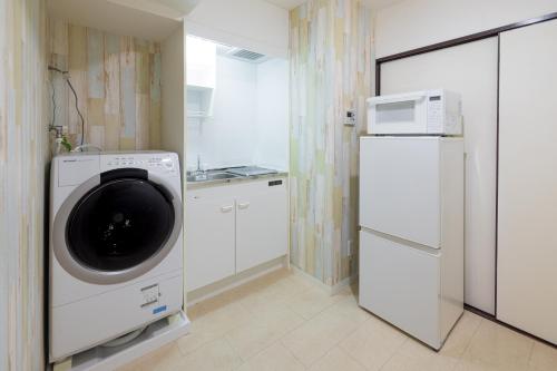 a kitchen with a washing machine and a refrigerator at エルザビル411 in Sumiyoshi
