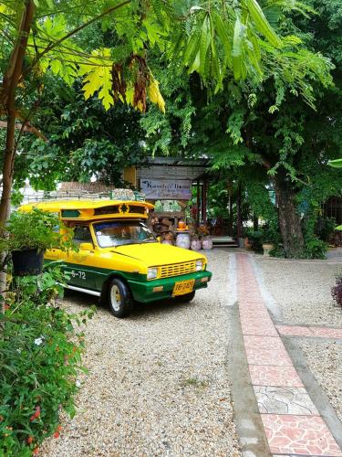 a yellow car parked on the side of a street at Kanecha's Home Lampang in Lampang