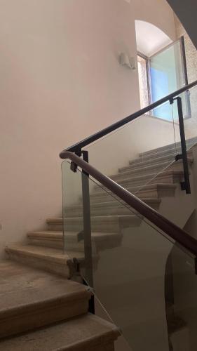 a staircase with a glass railing and a window at Palazzo Verrone in Bari