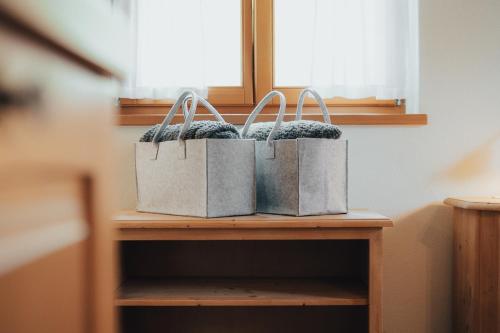 two shopping bags sitting on a shelf at Agriturismo Maso Besleri in Cembra
