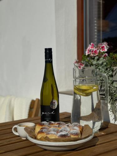 a table with a bottle of wine and a plate of bread at Apartmán Pure Harmony in Velké Bílovice