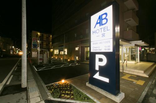 a hotel sign on the side of a street at night at AB Hotel Ichinomiya in Ichinomiya