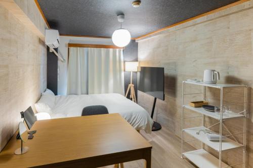 住吉にあるエルザビル416のベッドと机とテーブルがあるホテルの部屋