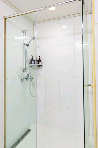 a shower with a glass door in a bathroom at Haru stay in Anyang