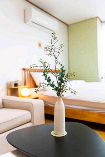 a white vase sitting on a table in a room at Haru stay in Anyang