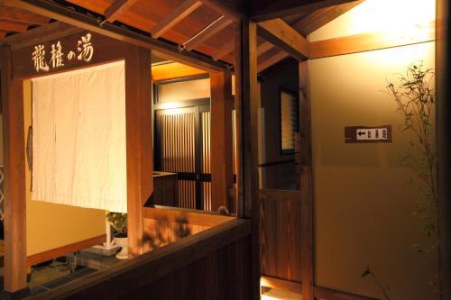 a door to a building with a sign on it at 和みの宿 弓ヶ浜いち番館 in Minamiizu