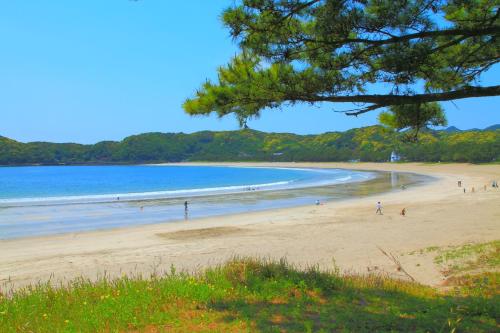 a group of people on a beach near the water at 和みの宿 弓ヶ浜いち番館 in Minamiizu