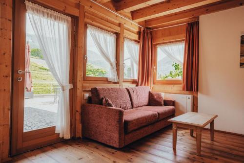 a living room with a couch and a window at Agriturismo Maso Besleri in Cembra