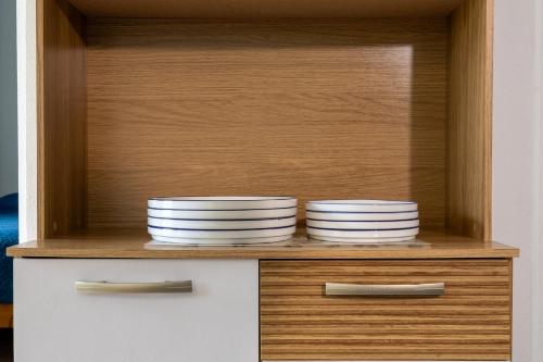 two plates are sitting on a shelf in a cabinet at Villas Cozy Sloth in Puerto Viejo