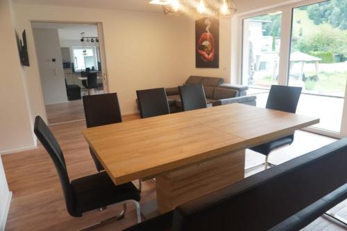 a dining room with a wooden table and chairs at Apartment Deluxe mit Whirlpool und Fasssauna in Imsterberg