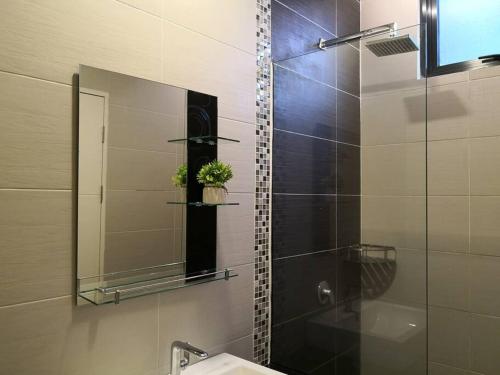 a bathroom with a shower with a mirror and a sink at Jk CozyHome 10Pax 100Mbps 2Carparks in Kuching