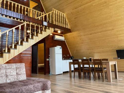 a kitchen and dining room with a table and a staircase at Aframe Villa Qabala in Gabala