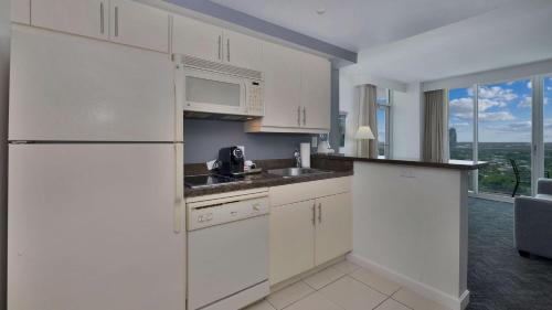 a white kitchen with a sink and a microwave at Hotel Arya BW Premier Collection in Miami