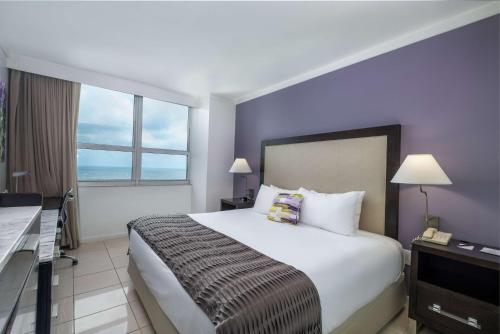 a hotel room with a large bed and a desk at Hotel Arya BW Premier Collection in Miami