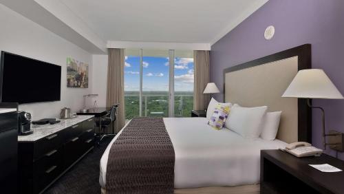 a bedroom with a large bed with a large window at Hotel Arya BW Premier Collection in Miami