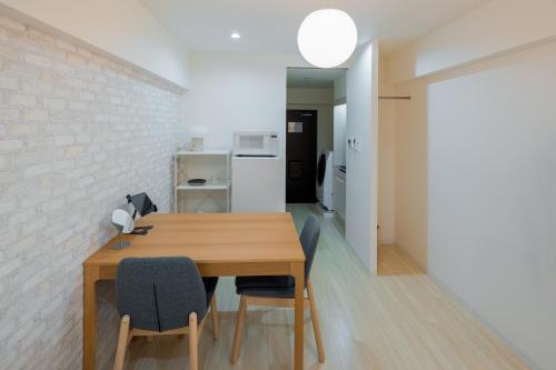 a dining room with a wooden table and chairs at エルザビル511 in Sumiyoshi