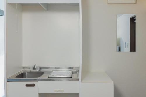 a kitchen with a sink and a mirror at エルザビル511 in Sumiyoshi