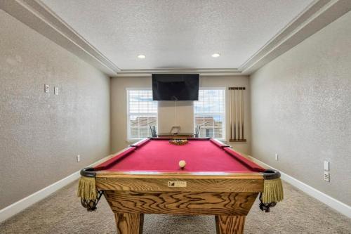 a red pool table in a room with a tv at 4BR Hot Tub Pool Table, Ping Pong, Foosball! in Peyton