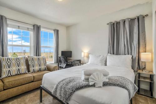 a bedroom with a large bed and a couch at 4BR Hot Tub Pool Table, Ping Pong, Foosball! in Peyton